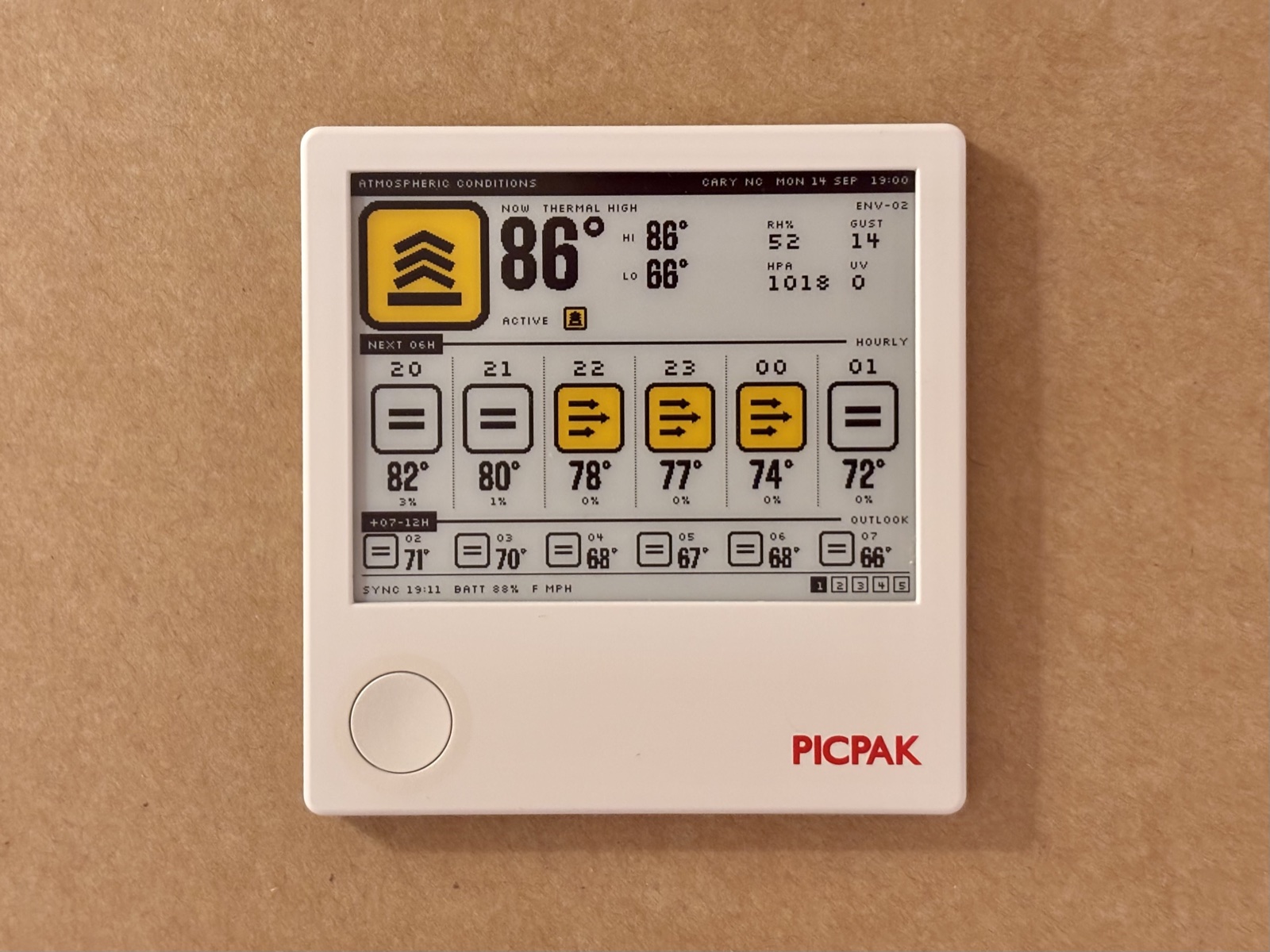 The PicPak frame on a wall, running Semiotic's Atmospheric Conditions screen: a yellow thermal placard, 86 degrees, and the next twelve hours as a row of hazard signs