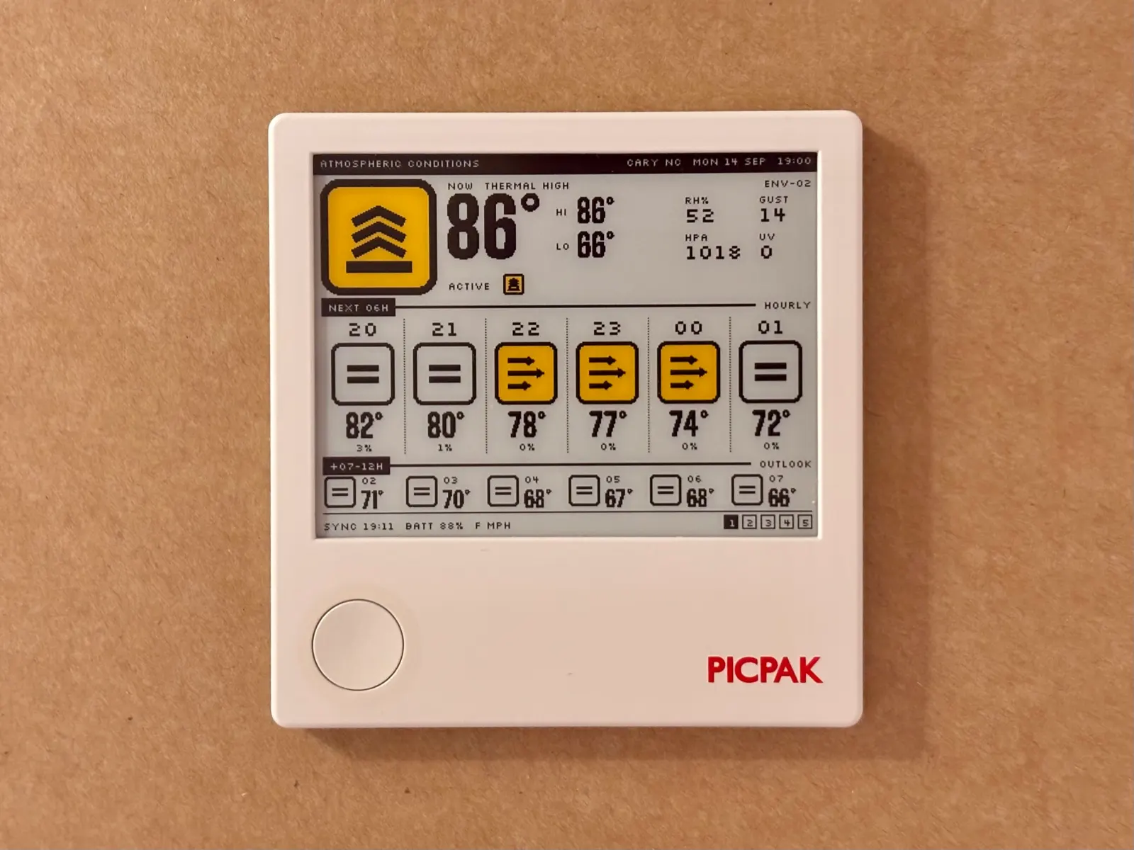 The PicPak frame on a wall, running Semiotic's Atmospheric Conditions screen: a yellow thermal placard, 86 degrees, and the next twelve hours as a row of hazard signs